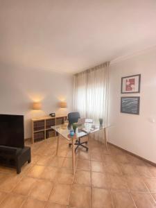a living room with a desk and a television at Aloha Burgau Guesthouse in Burgau