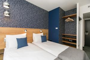 a bedroom with a large bed and a blue wall at Roombach Hotel Budapest Center in Budapest