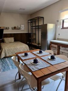 a room with a table and chairs and a kitchen at Residencial Vila das Canoas in Bombinhas