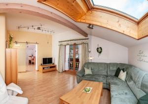 a living room with a green couch and a table at Ferienwohnung Gerti Huber - Chiemgau Karte in Inzell