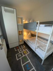 Zimmer mit 2 Etagenbetten und einer Tafel in der Unterkunft Ferienhaus Nordstrand in Horumersiel