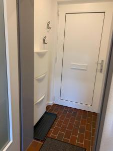 Un baño con puerta blanca y suelo de baldosas. en Ferienhaus Nordstrand, en Horumersiel 27 fotos más