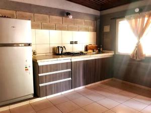 a kitchen with a stove and a refrigerator and a window at CABAÑA DORADA in Villa Ciudad de América
