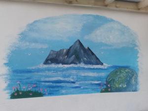 une peinture d'une montagne dans l'eau dans l'établissement Skellig View Harbour View Sunrise Apartment, à Portmagee