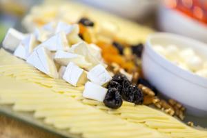 a plate of cheese and other food on a table at Roombach Hotel Budapest Center in Budapest
