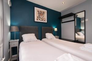 sypialnia z 2 łóżkami i niebieską ścianą w obiekcie Arena Apartments - Stylish and Homely Apartments by the Ice Arena with Parking w Nottingham