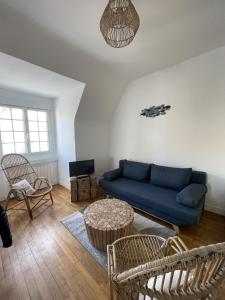 - un salon avec un canapé bleu et des chaises dans l'établissement Elliott, à Saint-Malo