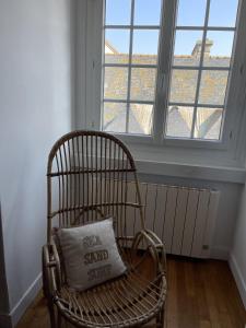 une chaise avec un oreiller assis devant une fenêtre dans l'établissement Elliott, à Saint-Malo