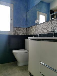 a bathroom with a toilet and a sink and blue walls at Beach front Esther 4 villajoyosa in Villajoyosa