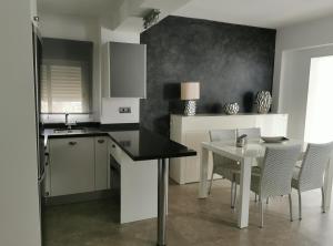 a kitchen with a table and a table and chairs at Beach front Esther 4 villajoyosa in Villajoyosa