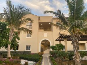 a large house with palm trees in front of it at Maqeela Luxury Studio in King Abdullah Economic City