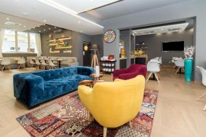 a living room with a blue couch and chairs at Roombach Hotel Budapest Center in Budapest