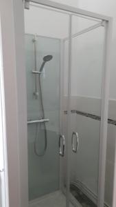 a shower with a glass door in a bathroom at La Maison de la Côte des Légendes in Brignogan-Plage