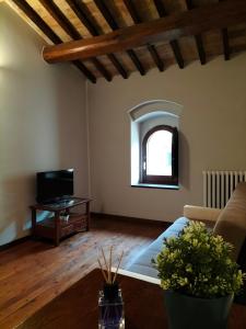 a living room with a couch and a tv at Casa Vacanze del Console in Bevagna