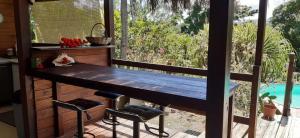 eine Veranda mit einem Holztisch und 2 Hockern in der Unterkunft Le Chalet Tropical in Le François