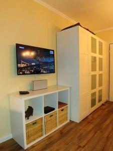 a white entertainment center with a tv on a wall at Fehmarn Burgtiefe Südstrand Meerblick Apartment MEERZEIT in Fehmarn