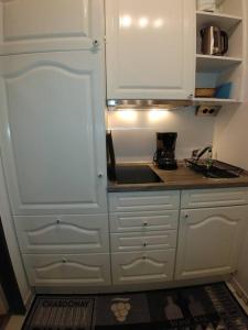 a kitchen with white cabinets and a counter top at Fehmarn Burgtiefe Südstrand Meerblick Apartment MEERZEIT in Fehmarn
