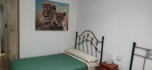 1 dormitorio con cama y una pintura de animales en Triana pura esencia, en Sevilla