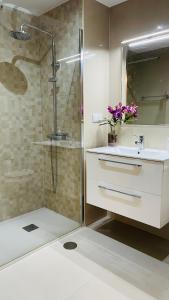 une salle de bain avec une douche, un lavabo et un miroir dans l'établissement Anadia Chic Apartment, à Funchal