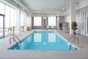 a large swimming pool in a large room with windows at Holiday Inn & Suites Montreal Airport in Dorval