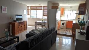 uma sala de estar com um sofá e uma cozinha em Apartamento Candelaria vivienda vacacional em Candelaria