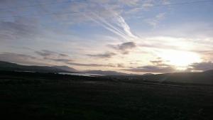 einen Blick auf ein Feld mit der Sonne am Himmel in der Unterkunft Skellig View Harbour View Sunrise Apartment in Portmagee