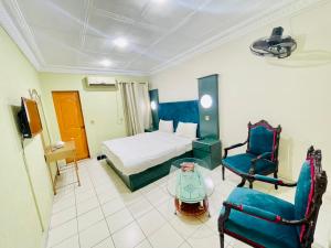 een hotelkamer met een bed en een tafel en stoelen bij Hotel New Mid City in Multan