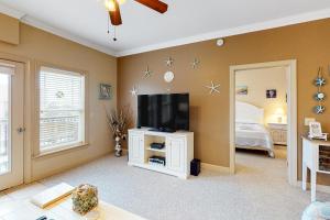 a living room with a tv and a bedroom at Ohana KDH122 in Kill Devil Hills