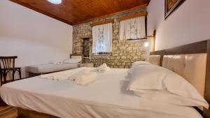 een slaapkamer met 2 bedden en een stenen muur bij Dhimitri Apartment in Berat