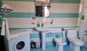 een badkamer met wastafel en wasmachine bij Dhimitri Apartment in Berat