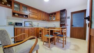 een keuken met houten kasten en een tafel en stoelen bij Dhimitri Apartment in Berat