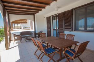 Un comedor con mesa y sillas de madera. en Villa Maldive del Salento, en Marina di Pescoluse