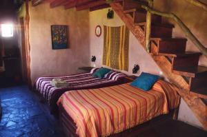 a bedroom with two beds and a staircase at Alojamiento Ecológico Kurache in Tandil