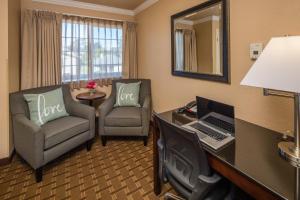 a hotel room with a desk and chairs and a laptop at Stage Coach Lodge in Monterey
