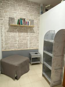 a room with a bed and a shelf with books at La Casetta in Santa Maria di Castellabate