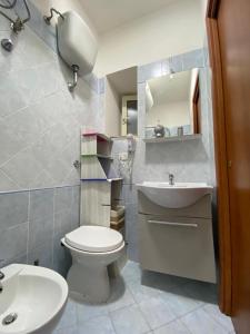 a bathroom with a white toilet and a sink at La Casetta in Santa Maria di Castellabate