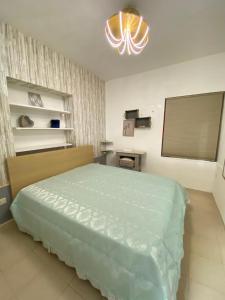 a bedroom with a bed and a chandelier at La Casetta in Santa Maria di Castellabate +24 photos