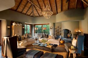 a living room filled with furniture and a chandelier at Madikwe Safari Lodge in Madikwe Game Reserve