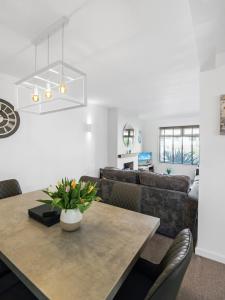 a living room with a table and a couch at Sid Valley View - Scenic end of terrace town house in Sidmouth