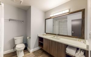 a bathroom with a sink and a toilet and a mirror at Super 8 by Wyndham Osoyoos in Osoyoos
