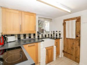 a kitchen with wooden cabinets and a sink at Gordon's View in Little Dean