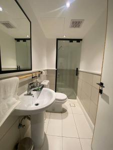 a bathroom with a sink and a toilet and a shower at فندق مساكن الجود in Al ‘Azīzīyah +30 photos