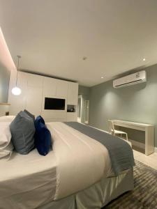 فندق مساكن الجود في Al ‘Azīzīyah: غرفة نوم مع سرير أبيض كبير ومكتب