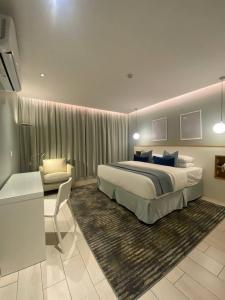 a bedroom with a king sized bed and a desk at فندق مساكن الجود in Al ‘Azīzīyah