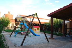einen Spielplatz mit Rutsche und Schaukel in der Unterkunft El Rincón de Arabayona in Arabayona