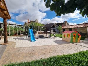 einen Spielplatz mit Rutsche und Schaukel in der Unterkunft El Rincón de Arabayona in Arabayona