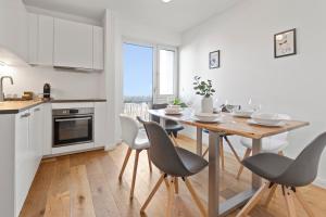 uma cozinha e sala de jantar com mesa e cadeiras em Flatista Homes - Hirschgarten em Munique