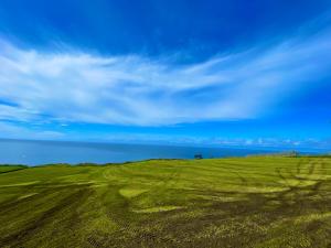 un campo de hierba verde con un cielo azul en Vivenda Luxuosa, en Feteiras