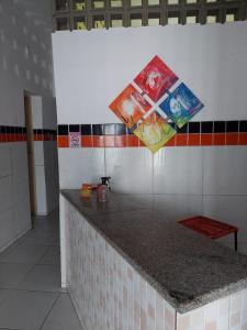 a kitchen with a counter with a kite on the wall at Pousada Bomfim in Maceió