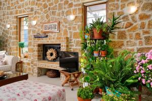 a living room with a stone wall with plants at Villa Bettina in Olympiada +23 photos